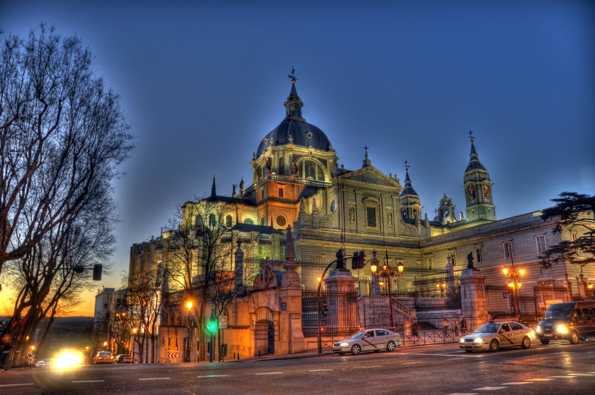 4K Ultra HD image of Almudena Cathedral at dusk, showcasing its illuminated religious architecture against a deep blue sky.