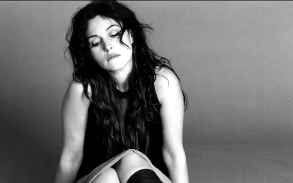 Monica Bellucci poses gracefully in this striking black and white HD desktop wallpaper, showcasing her timeless elegance and captivating presence.