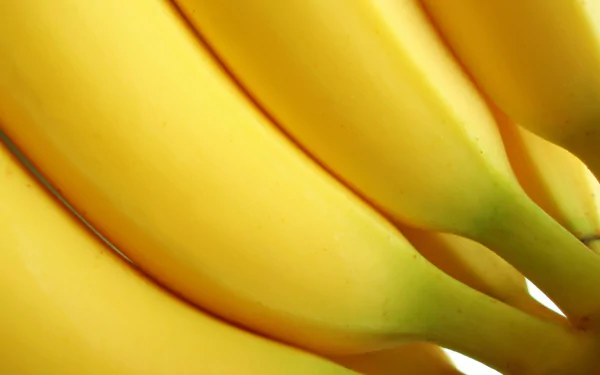 Close-up of ripe bananas with vibrant yellow skin, captured in 4K Ultra HD quality as a vivid PC desktop wallpaper and background.