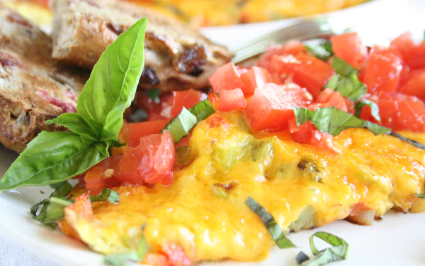 Close-up of a vibrant frittata topped with melted cheese, fresh diced tomatoes, and basil leaves, styled as an HD PC desktop wallpaper and background.
