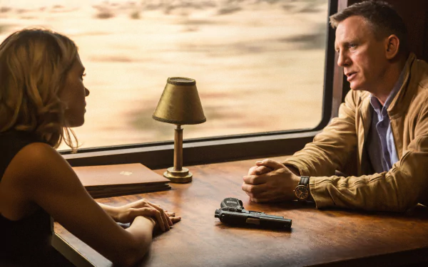 Léa Seydoux as Madeleine Swann and Daniel Craig as James Bond in a tense scene from the movie Spectre, set in an elegant train compartment with dramatic lighting.