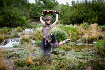 Lindsey Stirling striking a dynamic pose with her violin in a lush, natural setting, captured in stunning 4K Ultra HD for a vibrant music-themed desktop wallpaper.