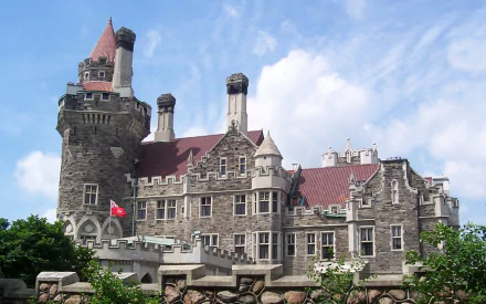 HD PC desktop wallpaper of Casa Loma: man-made stone castle with turrets and red roofs set against a bright blue sky.