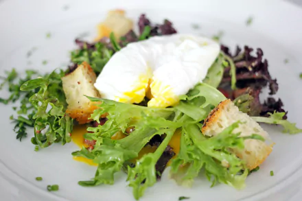 Close-up of a Salade Lyonnaise with fresh lettuce, a poached egg, and croutons, captured in 4K Ultra HD as a vibrant lunch meal wallpaper.