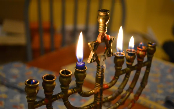 4K Ultra HD desktop wallpaper featuring a lit Hanukkah menorah with glowing flames, celebrating the holiday in a warm, cozy setting.