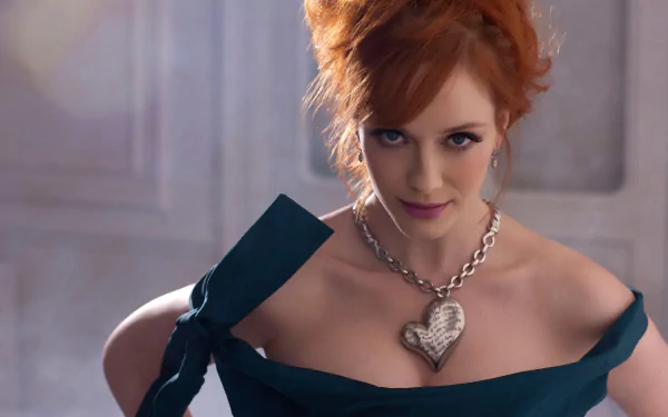 A high-definition wallpaper featuring American actress Christina Hendricks, showcasing her striking red hair and elegant attire, highlighted by a bold heart-shaped necklace.