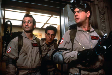 A vibrant HD wallpaper featuring Dan Aykroyd, Bill Murray, and Harold Ramis in iconic Ghostbusters gear, ready for an adventure in an elevator setting.