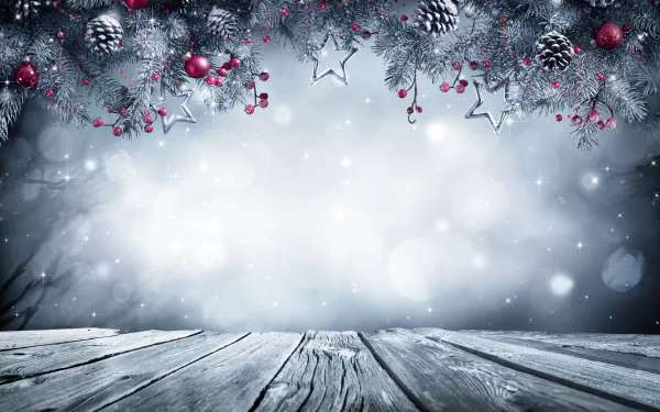 A festive HD desktop wallpaper featuring Christmas ornaments, pinecones, and berries hanging over a wooden surface with a frosty, snowy background.