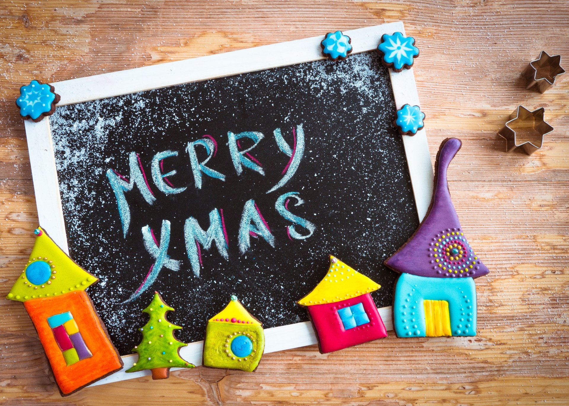 4K Ultra HD PC wallpaper: blackboard chalked Merry Xmas surrounded by colorful holiday house ornaments and star cookie cutters — Christmas background.