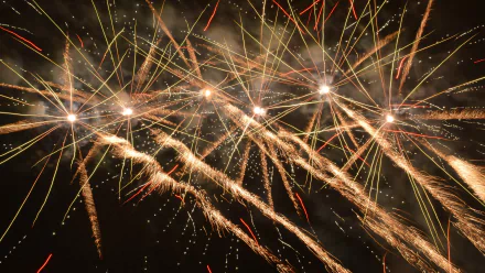 Vibrant fireworks burst in a night sky, captured in stunning 4K Ultra HD, celebrating the New Year with lively sparks and radiant light streaks.