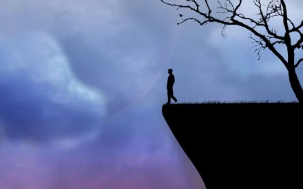 Artistic HD PC desktop wallpaper depicting a solitary human figure standing at the edge of a cliff under a twilight sky with a bare tree nearby.
