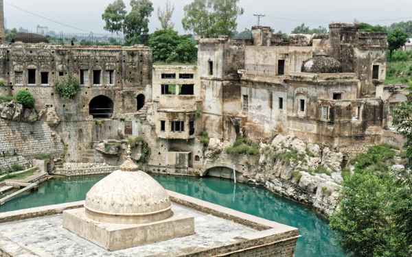 5K Ultra HD desktop wallpaper: Katasraj Temple, Pakistan — ancient religious stone temple and domed shrine reflected in tranquil turquoise water.