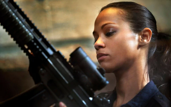 HD desktop wallpaper featuring Zoe Saldana from the movie Colombiana, holding a weapon with a focused expression.