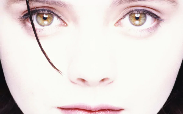 Close-up HD desktop wallpaper of celebrity Christina Ricci with striking hazel eyes and pale complexion, capturing an intense and ethereal expression.