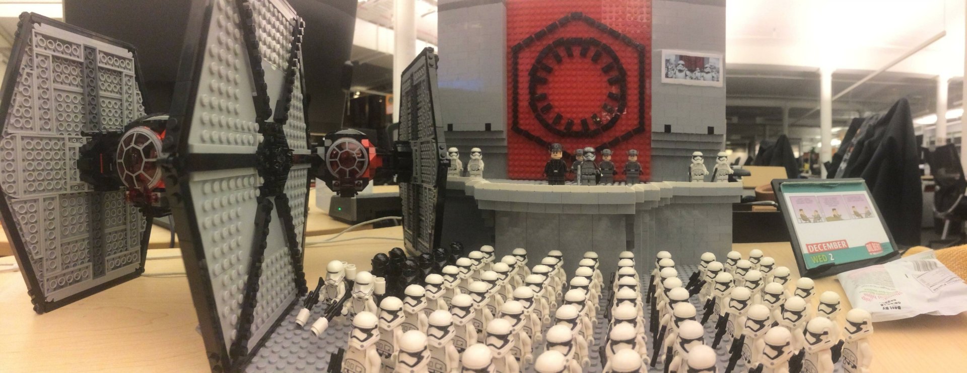 LEGO Star Wars Sci‑Fi scene: ranks of stormtrooper minifigures face a raised dais with officers and a TIE Fighter — 2K Quad HD PC desktop wallpaper/background.