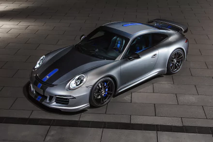 A sleek silver Porsche 911 Carrera supercar with blue accents, showcased on a modern tiled surface, serving as an impressive HD desktop wallpaper.