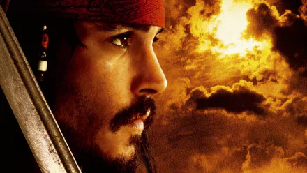 HD desktop wallpaper featuring Johnny Depp as Jack Sparrow from Pirates of the Caribbean: The Curse of the Black Pearl, with a dramatic sunset highlighting his profile.