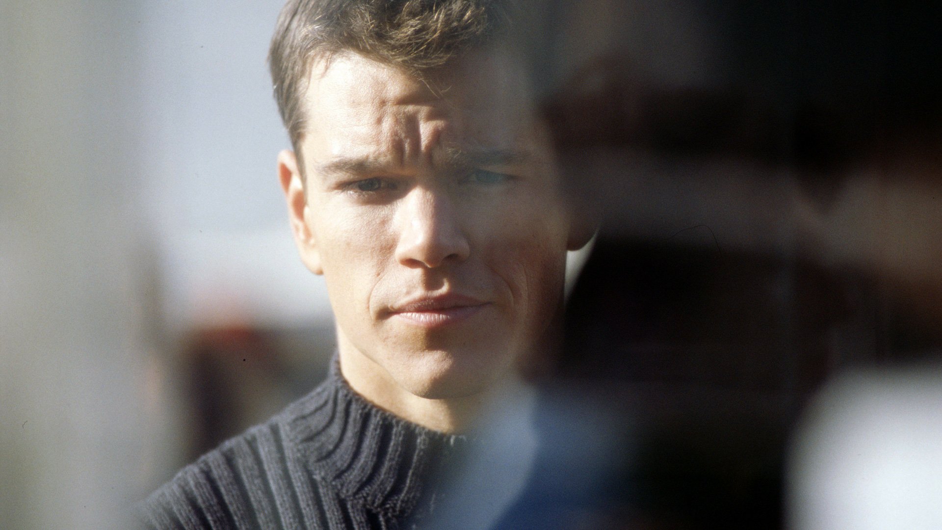 HD PC desktop wallpaper featuring a close-up of Matt Damon in a reflective moment from the movie The Bourne Identity.