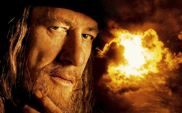 Close-up of Hector Barbossa from Pirates of the Caribbean: The Curse of the Black Pearl — weathered pirate face against a fiery, stormy sky, HD desktop wallpaper.