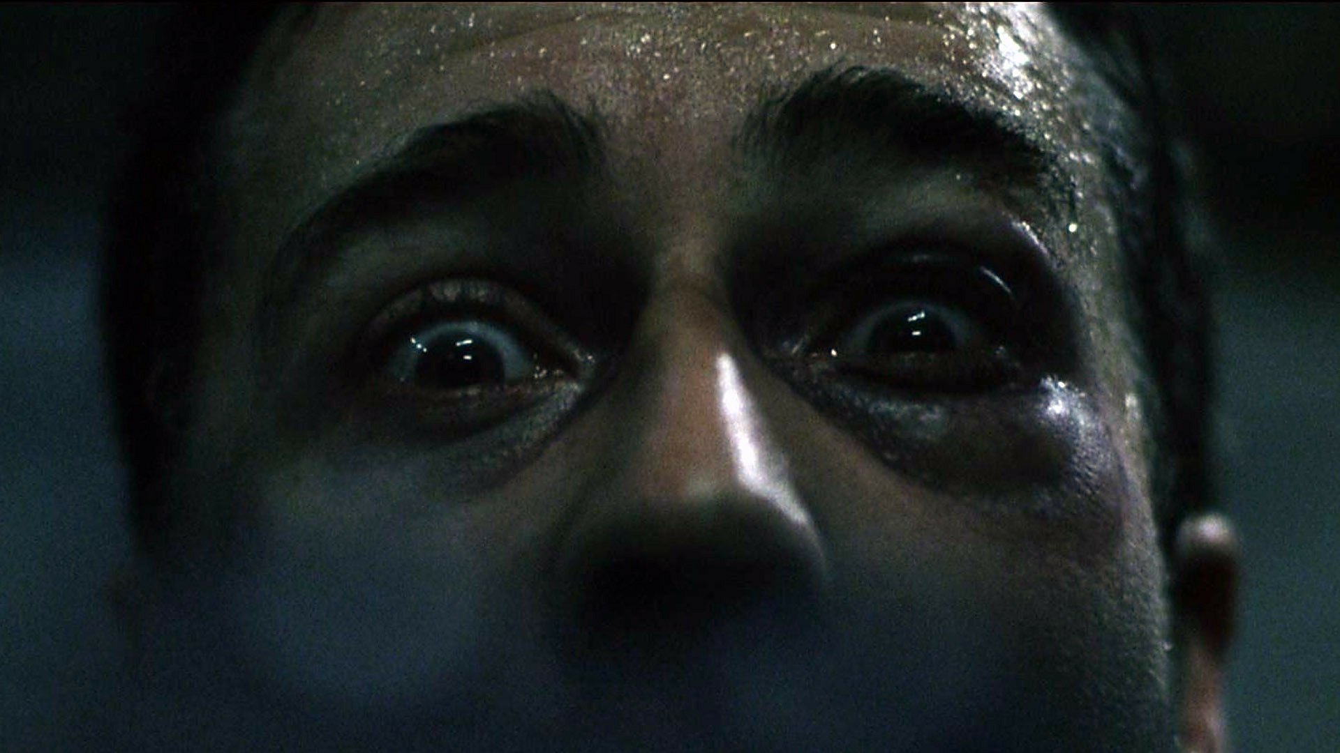 HD PC desktop wallpaper: extreme close-up of a sweaty, wide-eyed terrified face from the movie Fight Club, low-lit and intensely dramatic.
