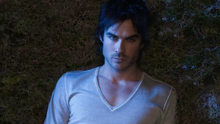 HD desktop wallpaper of Ian Somerhalder from the TV show The Vampire Diaries, featuring him lying on the ground with a serious expression.