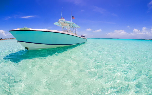HD PC desktop wallpaper and background: white speed boat vehicle on turquoise-blue ocean with crystal-clear shallow water and a bright sunny sky.