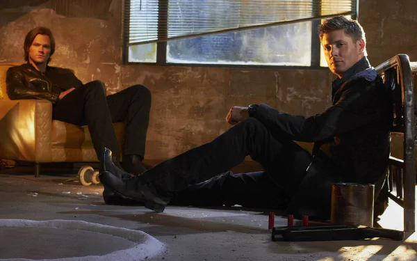 HD desktop wallpaper featuring Jensen Ackles as Dean Winchester and Jared Padalecki as Sam Winchester from the TV show Supernatural, set against an atmospheric backdrop.