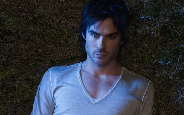 HD desktop wallpaper of Ian Somerhalder from the TV show The Vampire Diaries, featuring him lying on the ground with a serious expression.