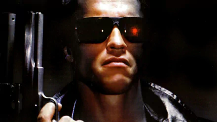 Arnold Schwarzenegger in a dramatic pose from the movie The Terminator, showcasing his iconic look with sunglasses and a gun, set against a dark background.