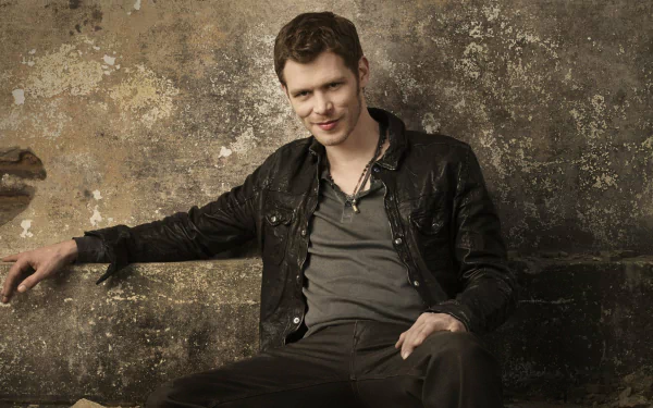 A still from the TV show *The Originals*, featuring a male character in a leather jacket against a textured wall, showcasing a confident and casual vibe. HD wallpaper and background.
