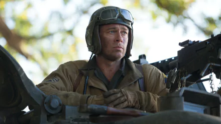 A high-definition desktop wallpaper featuring Brad Pitt in a scene from the movie Fury, showcasing his serious expression while seated in a tank.