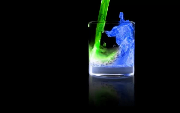 Artistic HD wallpaper featuring a glass with vibrant green and blue liquids swirling together against a black background, evoking elemental themes.