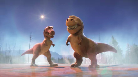 HD desktop wallpaper featuring two dinosaurs from the movie The Good Dinosaur, set against a scenic background with a bright sky and distant mountains.