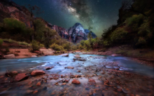 Night sky with the Milky Way over a rocky river and cliffs in Zion National Park, Utah, showcasing stunning mountain nature at star-filled night.