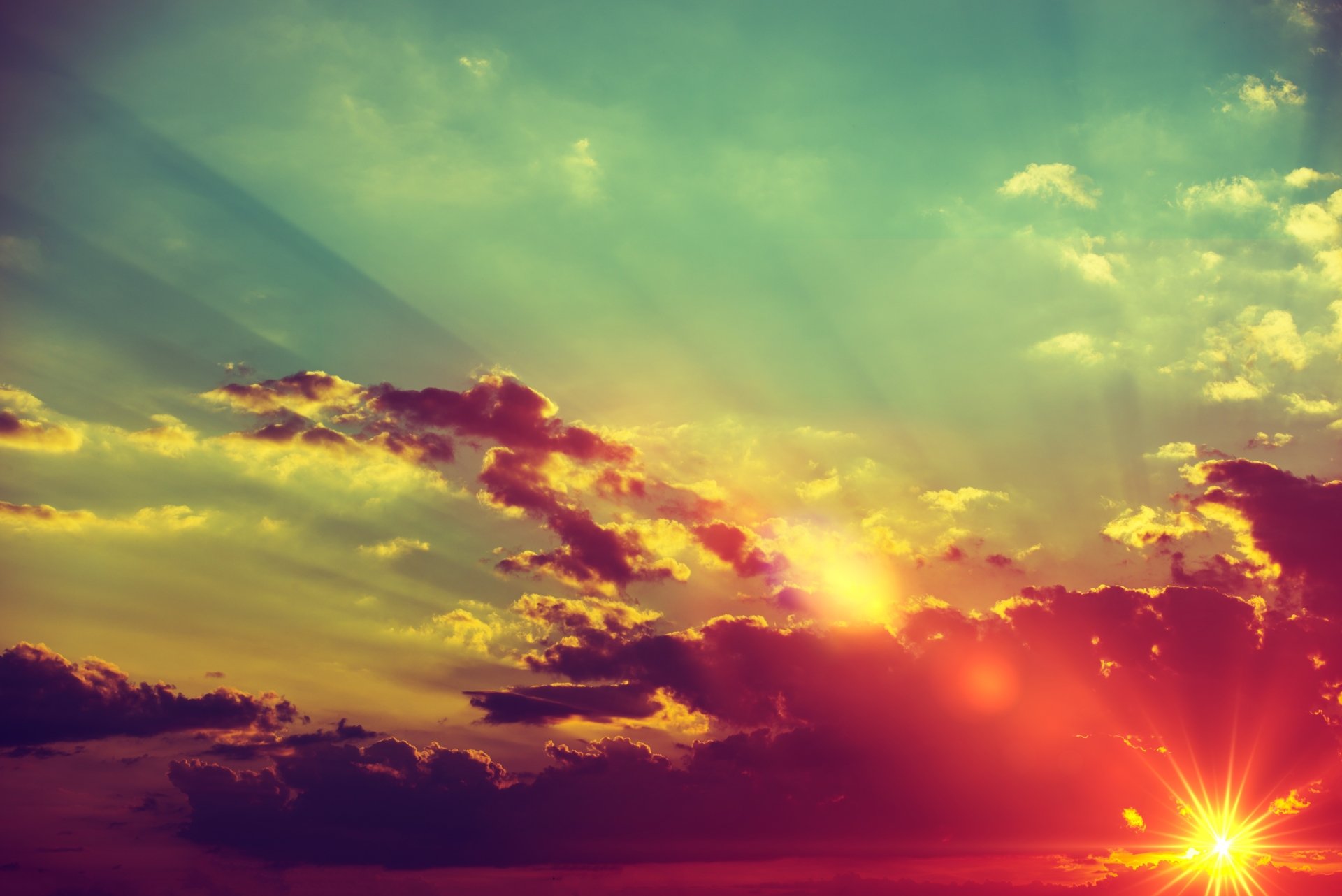 A vibrant 4K Ultra HD desktop wallpaper capturing sunbeams piercing through clouds during a colorful sunset sky in nature.