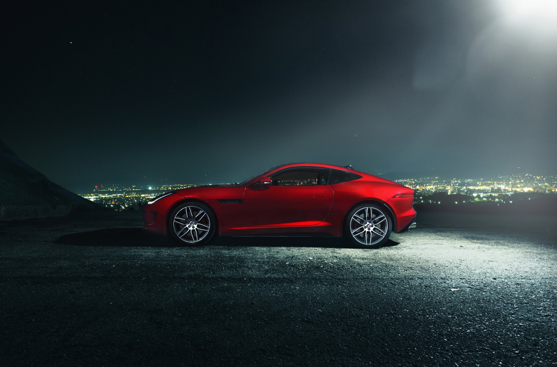 Red Jaguar F-Type sports vehicle parked at night overlooking a city skyline — HD PC desktop wallpaper/background.