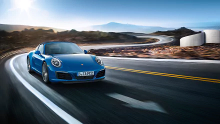 Blue Porsche 911 Targa car on a coastal winding road at sunrise — 2K Quad HD PC desktop wallpaper of the Porsche 911 sports vehicle.