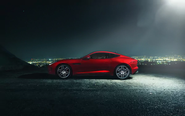 Red Jaguar F-Type sports vehicle parked at night overlooking a city skyline — HD PC desktop wallpaper/background.