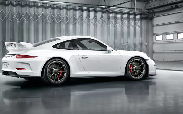 White Porsche 911 GT3 sports car showcased in a spacious, modern garage with reflective flooring, captured in high-definition for a PC desktop wallpaper.