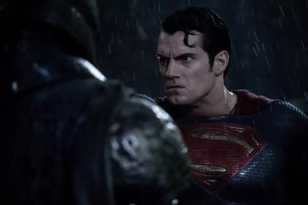 Henry Cavill as Superman, drenched in rain, faces off against a shadowy figure in a dramatic scene from *Batman V Superman: Dawn Of Justice*. HD wallpaper featuring intense action.