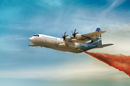 Lockheed Martin L-100 Hercules aerial firefighting aircraft releasing fire retardant over terrain — HD PC desktop wallpaper background.