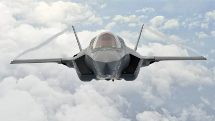 A Lockheed Martin F-35 Lightning II jet fighter soars through the clouds, showcasing its sleek design and advanced military capabilities in this HD wallpaper.