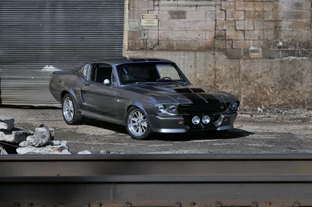 Silver Ford Mustang GT500 muscle car parked by an industrial brick wall — 4K Ultra HD PC desktop wallpaper/background.