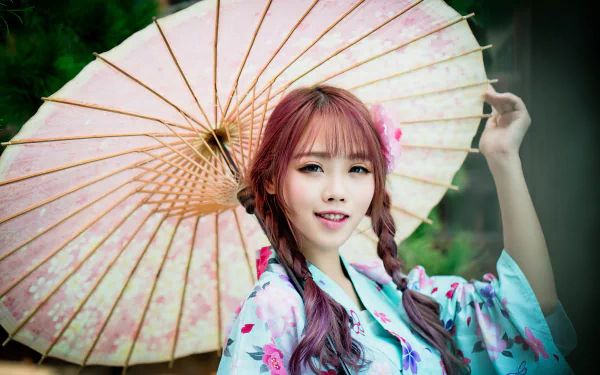 A woman with a braid smiles warmly while holding a pink umbrella, dressed in a floral kimono. The HD image captures an elegant, serene atmosphere inspired by oriental aesthetics.