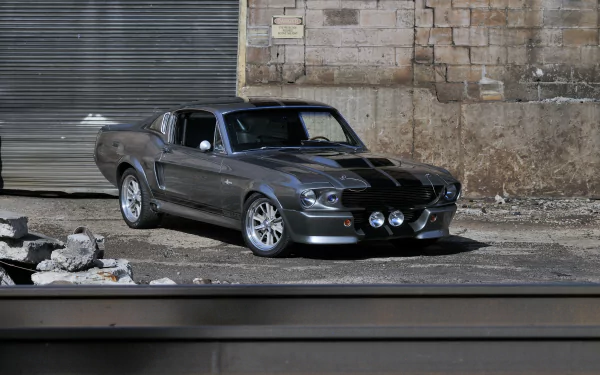 Silver Ford Mustang GT500 muscle car parked by an industrial brick wall — 4K Ultra HD PC desktop wallpaper/background.