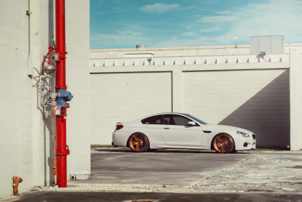 White BMW M6 parked beside a white building under a clear blue sky in this 4K Ultra HD desktop wallpaper and background.