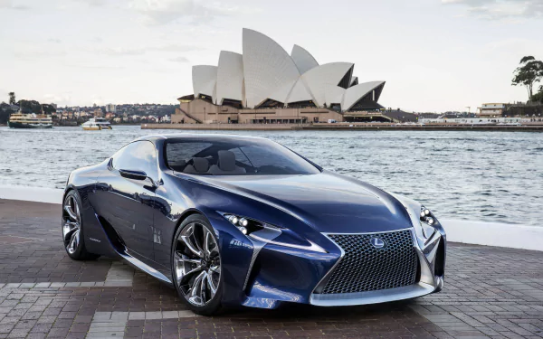 A sleek blue Lexus LC 500 parked by the waterfront with the iconic Sydney Opera House in Australia in the background, captured in HD for a desktop wallpaper.