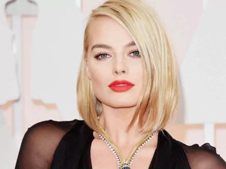 Margot Robbie, the Australian actress, showcases her striking blue eyes and bold red lipstick, complemented by a stunning necklace in this HD wallpaper background.