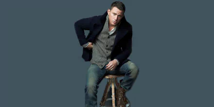 HD PC desktop wallpaper featuring American actor and celebrity Channing Tatum seated on a stool against a solid dark background.