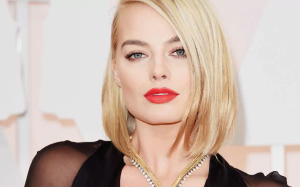 Margot Robbie, the Australian actress, showcases her striking blue eyes and bold red lipstick, complemented by a stunning necklace in this HD wallpaper background.